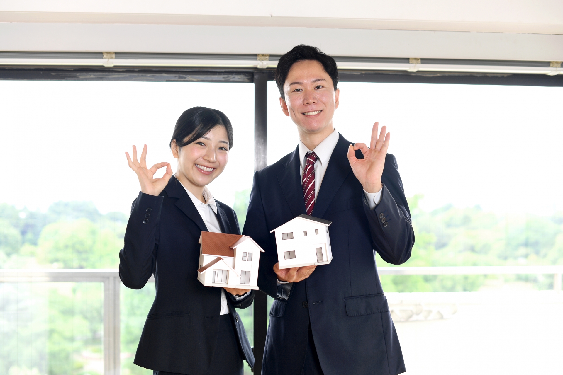 OKサインを出すスーツ姿の人二人